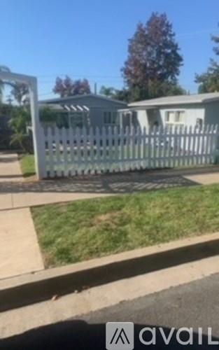 A white picket fence in front of a house.