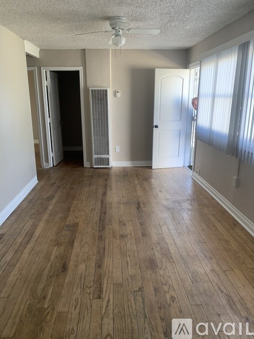A room with wooden flooring and a ceiling fan.