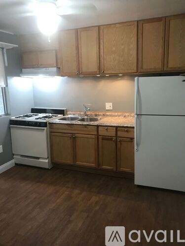 A kitchen with wooden cabinets and a white fridge.