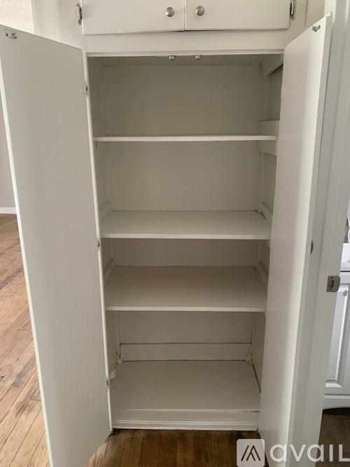 Empty white shelves in a white cabinet.