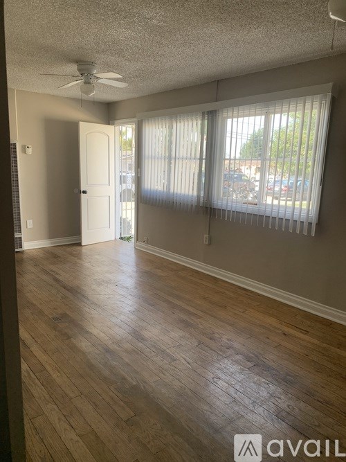 A room with wooden floors and a ceiling fan.