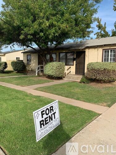 A house is for rent with a sign in front of it.