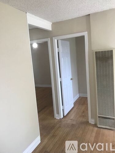 A room with a white door and a wall-mounted air conditioner.