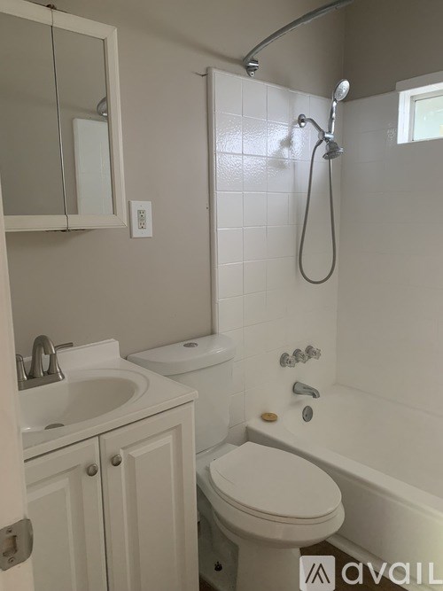 A white bathroom with a toilet, sink, and bathtub.