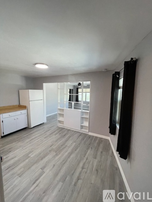 A spacious room with a grey floor and white walls.