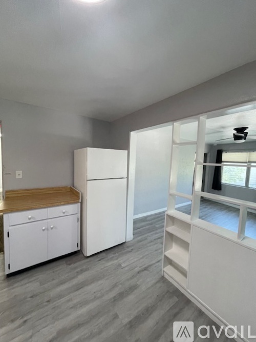 A kitchen with white cabinets and a wooden countertop.