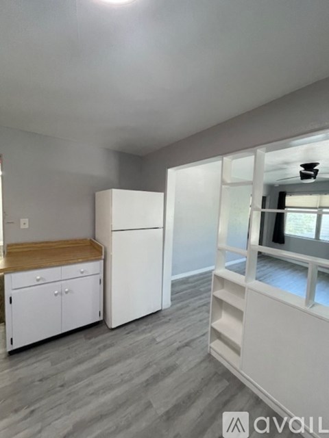 A kitchen with white cabinets and a wooden countertop.