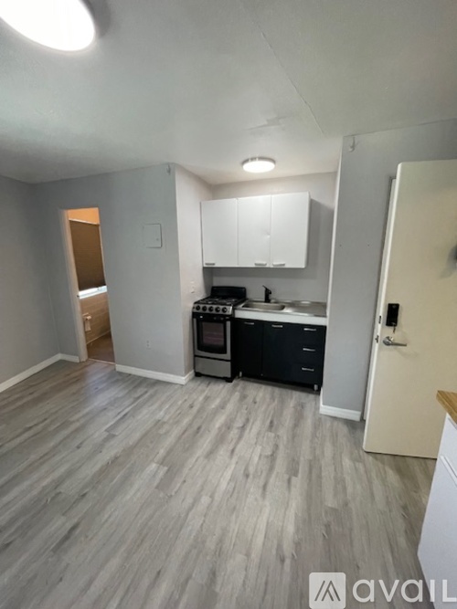 A kitchen area with a stove top oven and a refrigerator.