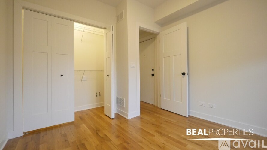 A BEALPROPERTIES ad for a room with white doors and wooden floors.