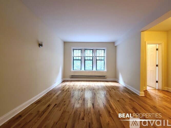 A room with wooden floors and a window is available for rent.