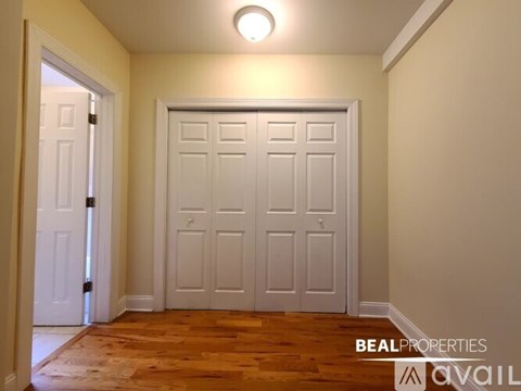 A white door is in a room with wooden floors.