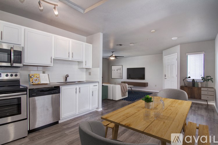 A modern kitchen with white cabinets and stainless steel appliances.