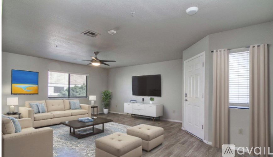 A living room with a television, a couch, a chair, and a painting on the wall.