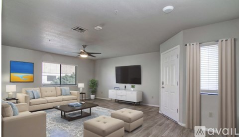 A living room with a television, a couch, a chair, and a painting on the wall.