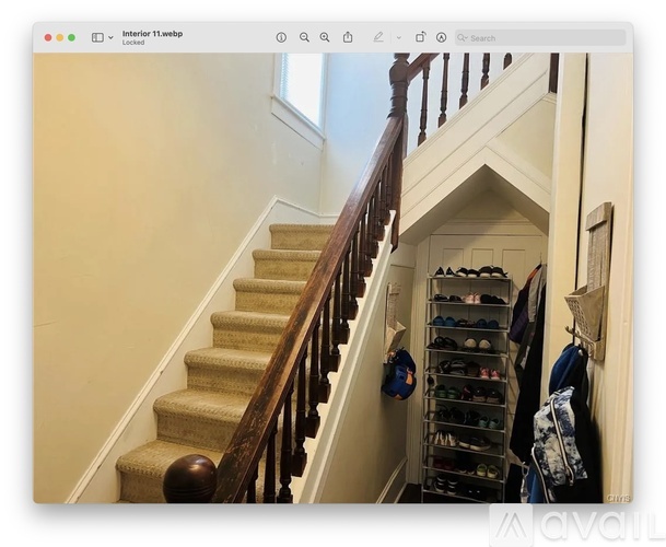 A staircase with a rack of shoes on the side.