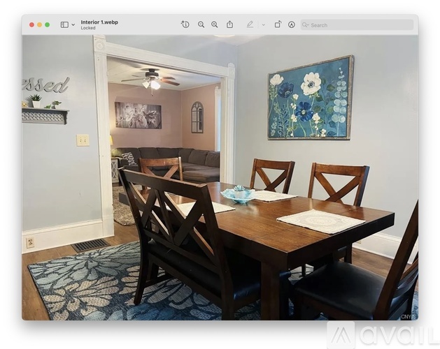 A dining room with a wooden table and chairs.