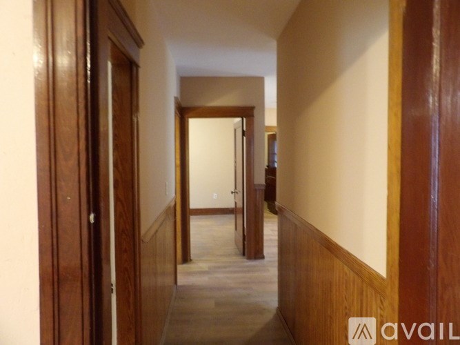 A hallway with wooden doors and a logo that says "AVAIL" on the wall.