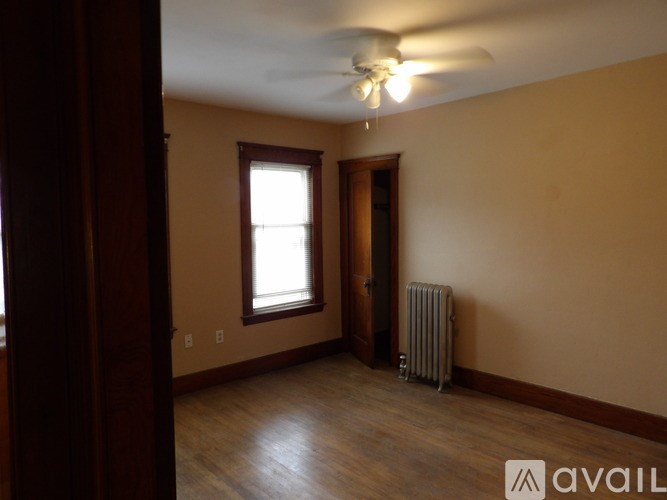 A room with a ceiling fan and a window.