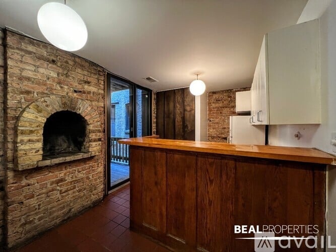 A brick fireplace is built into a wall in a room with a wooden counter.