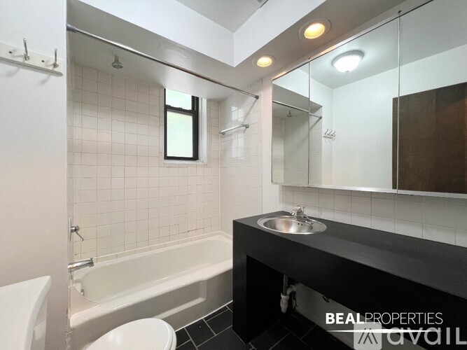 A bathroom with a white tub, sink, and toilet.