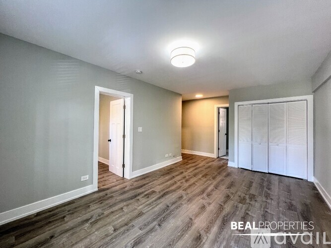 A spacious room with wood flooring and a white ceiling light.