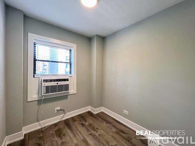 A room with a window and air conditioner installed on the wall.