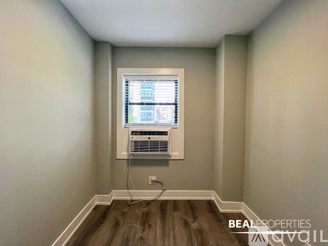 A BEALPROPERTIES sign is on a wall in a room with a window and air conditioner.