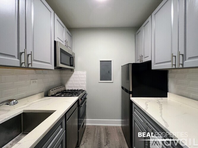 A kitchen with black appliances and white cabinets.