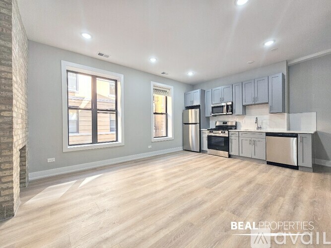 A spacious kitchen with wooden flooring and modern appliances.