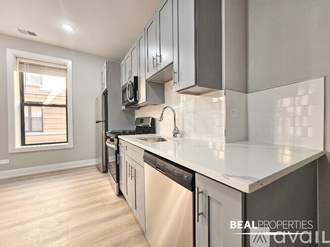 A modern kitchen with a dishwasher and microwave built into the cabinetry.