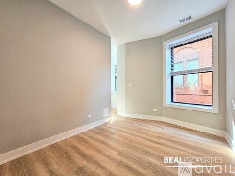 A room with a window showing a view of a building outside.
