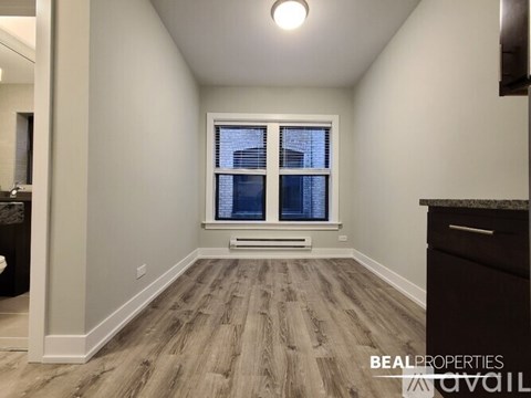 A room with a window and a wooden floor.