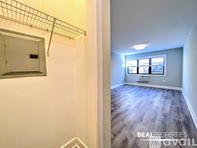 A BEALPROPERTIES sign is on a wall in an empty room with a window.