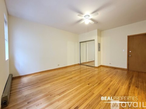 A room with wooden flooring and a ceiling fan.