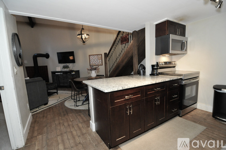 A kitchen with dark wood cabinets and a white countertop.