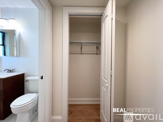 A white toilet is in a small bathroom with a white door.