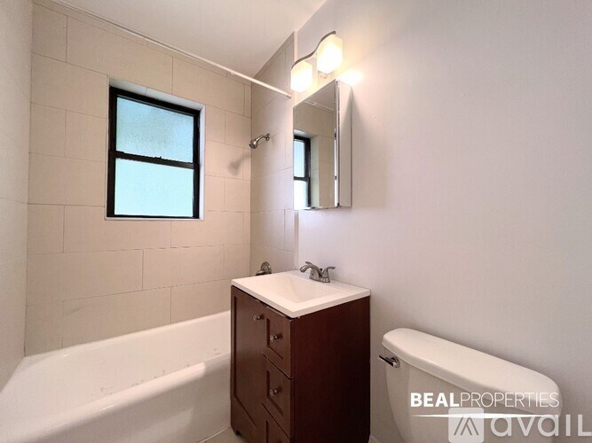 A bathroom with a tub, sink, and mirror.