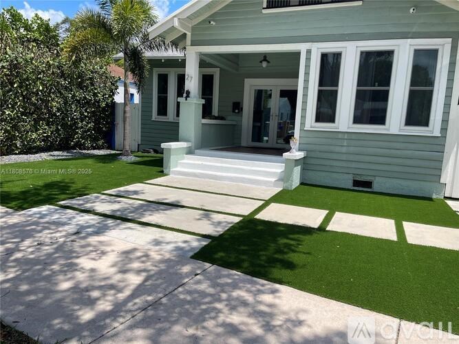 A house with a green lawn and a white front porch.