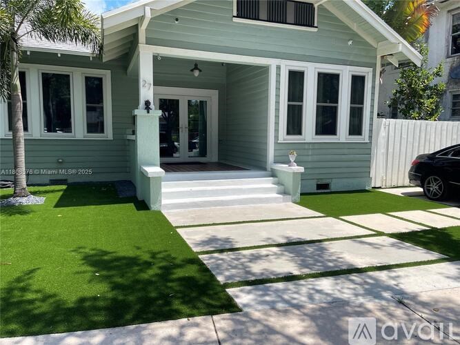 A house with a green front yard and a white fence.