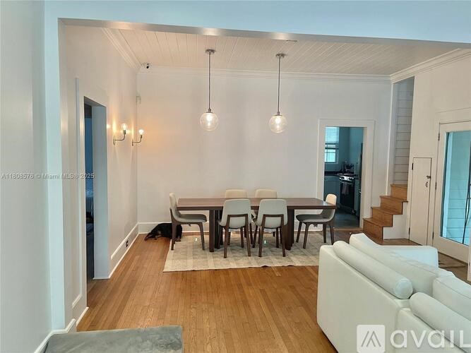 A living room with a dining table and chairs.