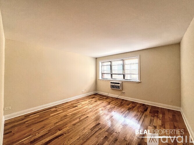 A room with wooden flooring and a window.