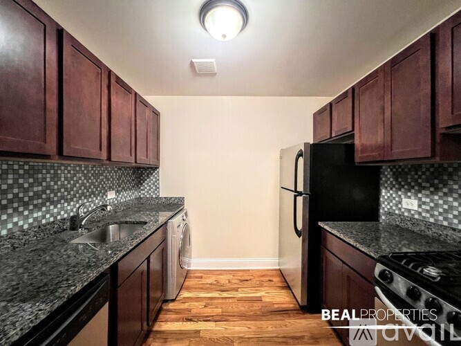 A kitchen with dark wood cabinets and black appliances.