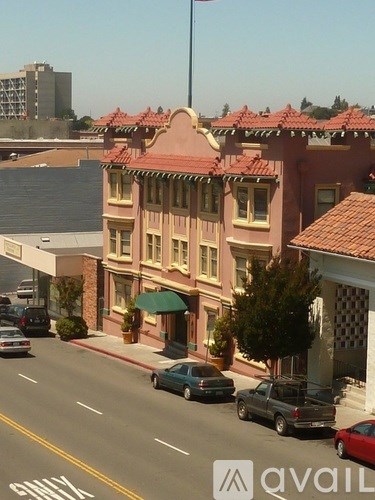 A street view of a town with a building that has a red roof.
