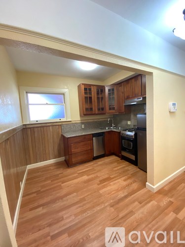 A kitchen with wooden cabinets and a stainless steel refrigerator.