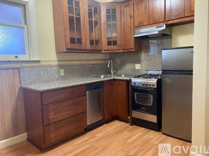 A kitchen with wooden cabinets and a stainless steel refrigerator.