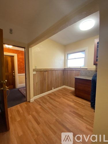 A room with wooden flooring and a window.