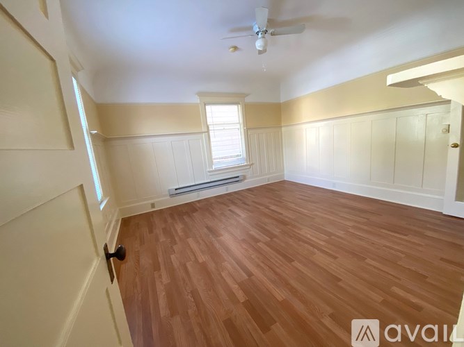 A room with wooden flooring and a window.