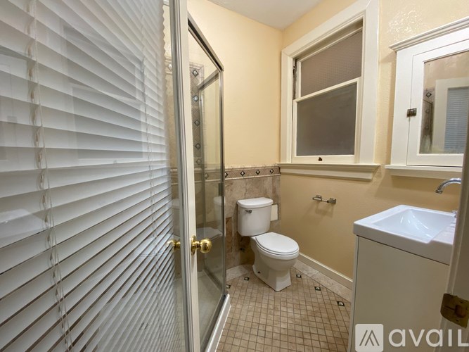 A bathroom with a toilet, sink, and shower.