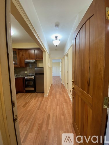 A hallway with wooden floors and doors on either side.