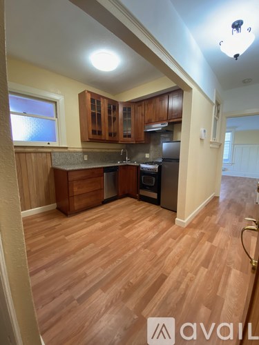 A kitchen with wooden floors and cabinets.